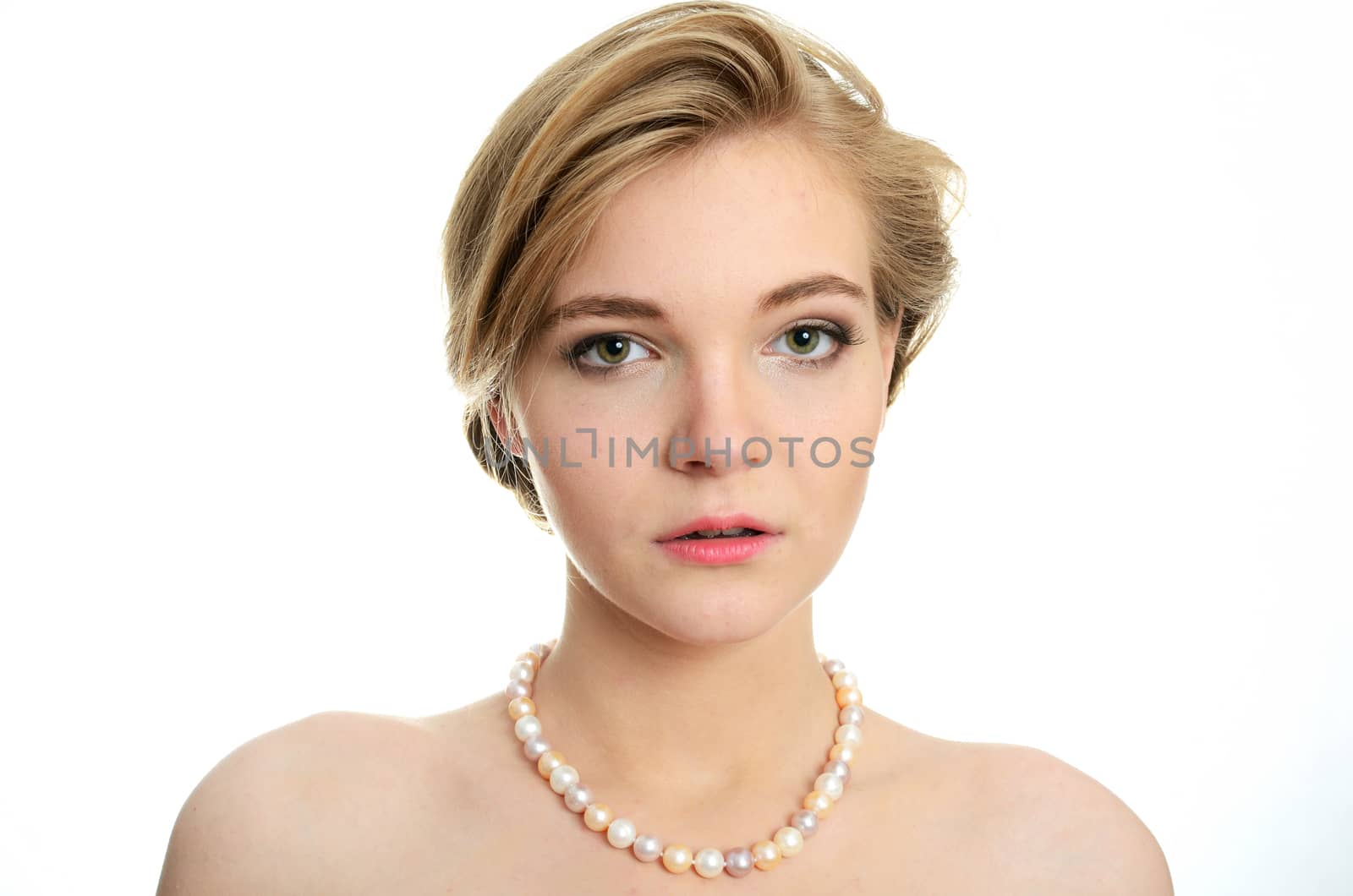 Beautiful female model with pearls on her neck. Portrait of young girl with soft and kind face expression.