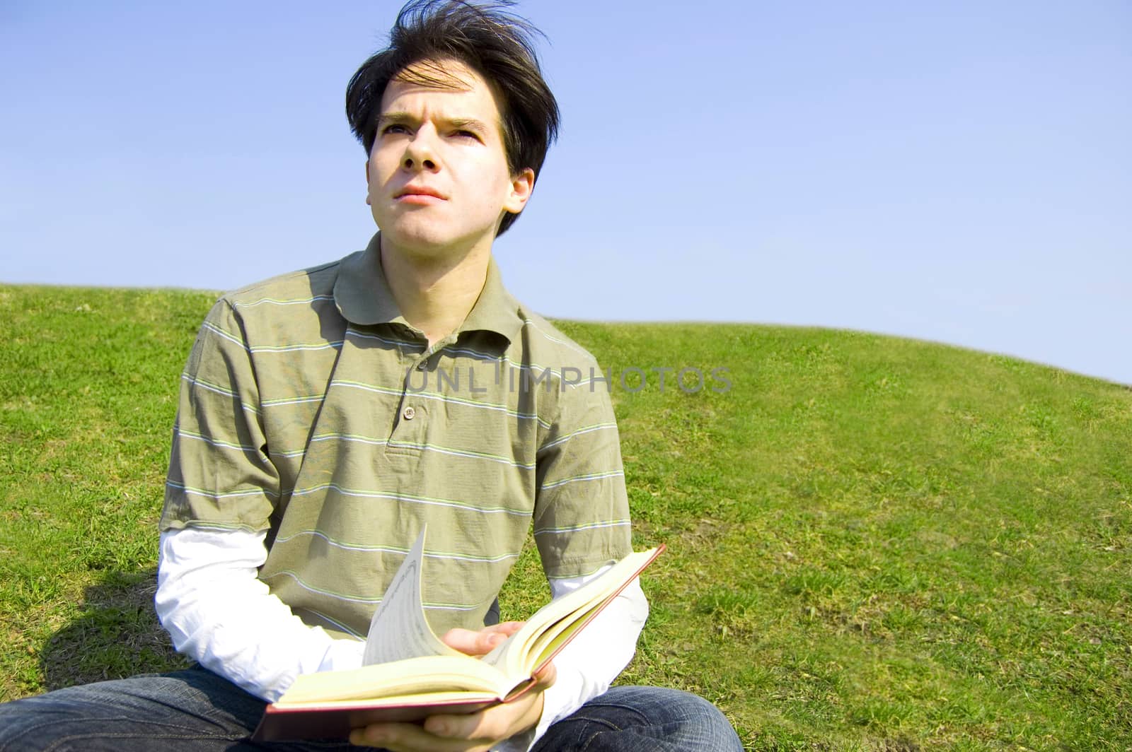 Education conceptual image. Teeneger student reading a book outdoors.