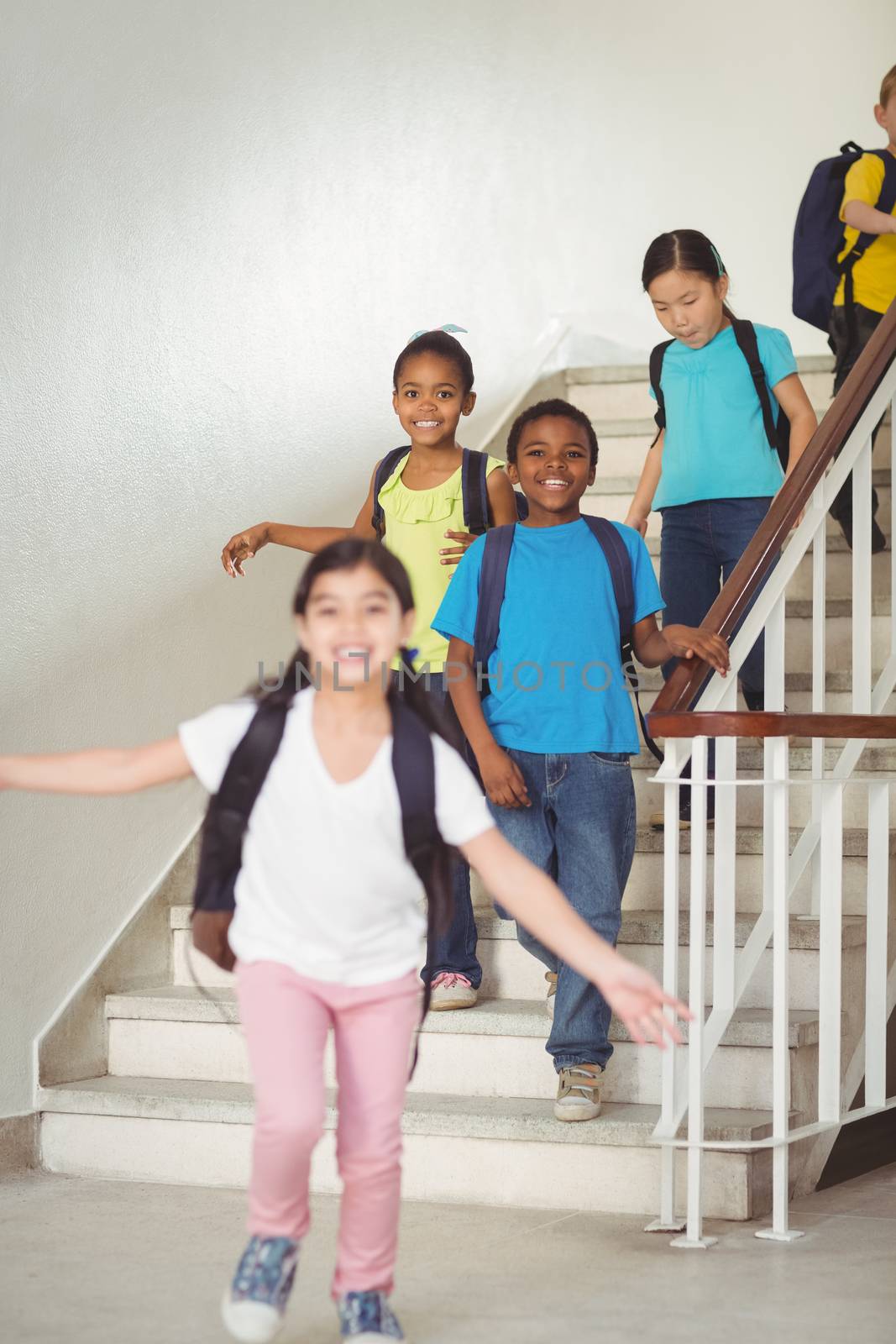 Happy pupils walking down the stairs by Wavebreakmedia