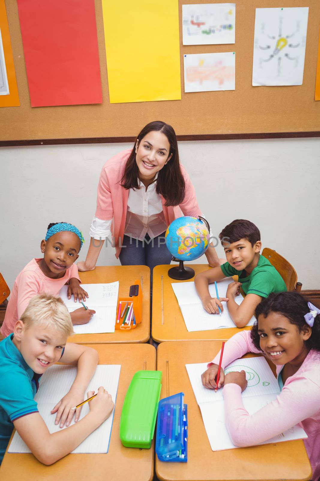 Smiling students and teacher looking at the camera by Wavebreakmedia