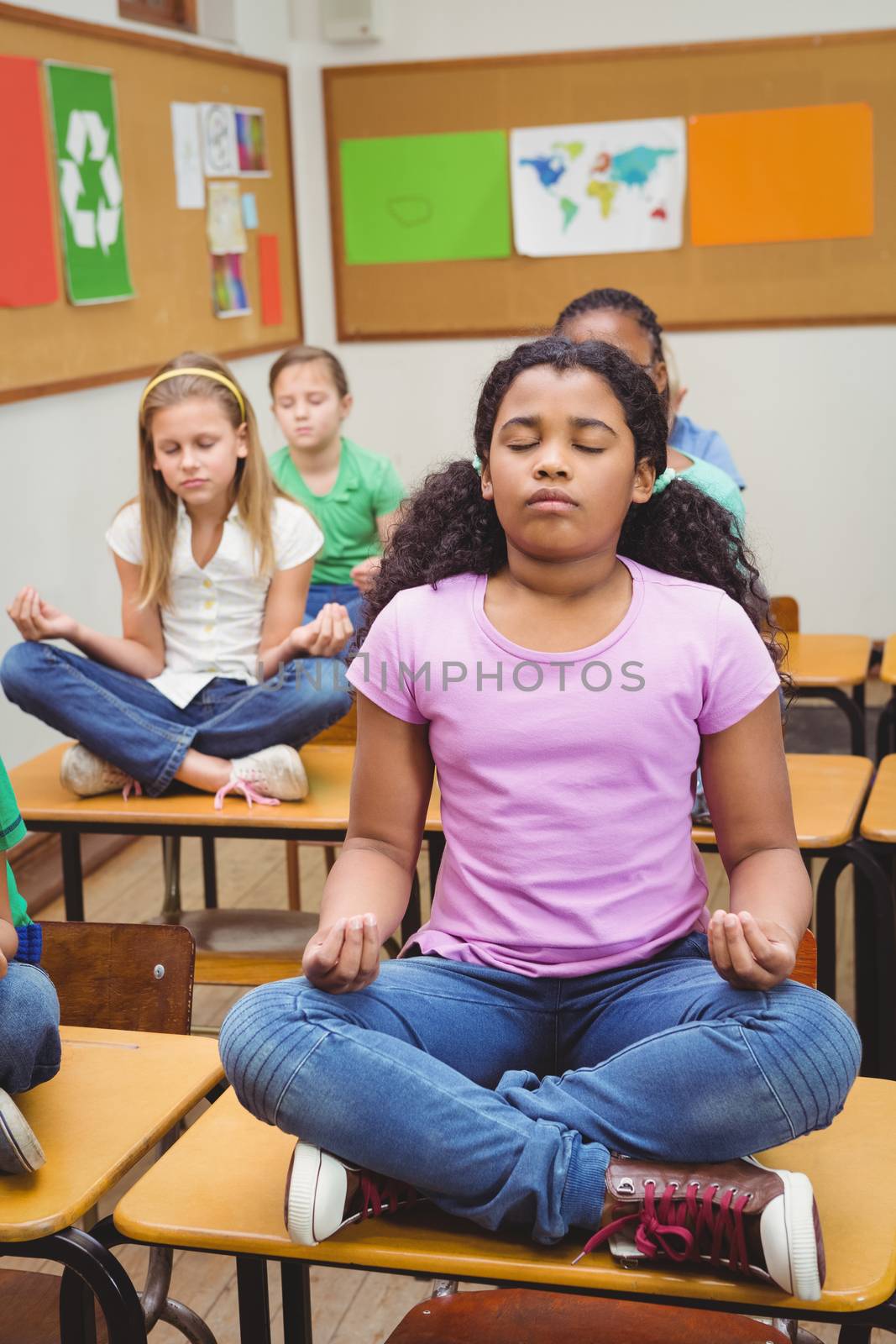 Pupils meditating on classroom desks at the elementary school