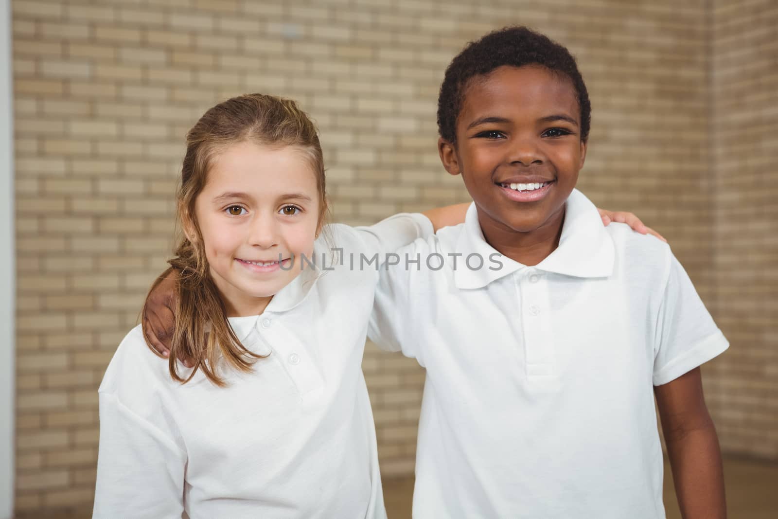 Pupils smiling with arms around each other in elementary school