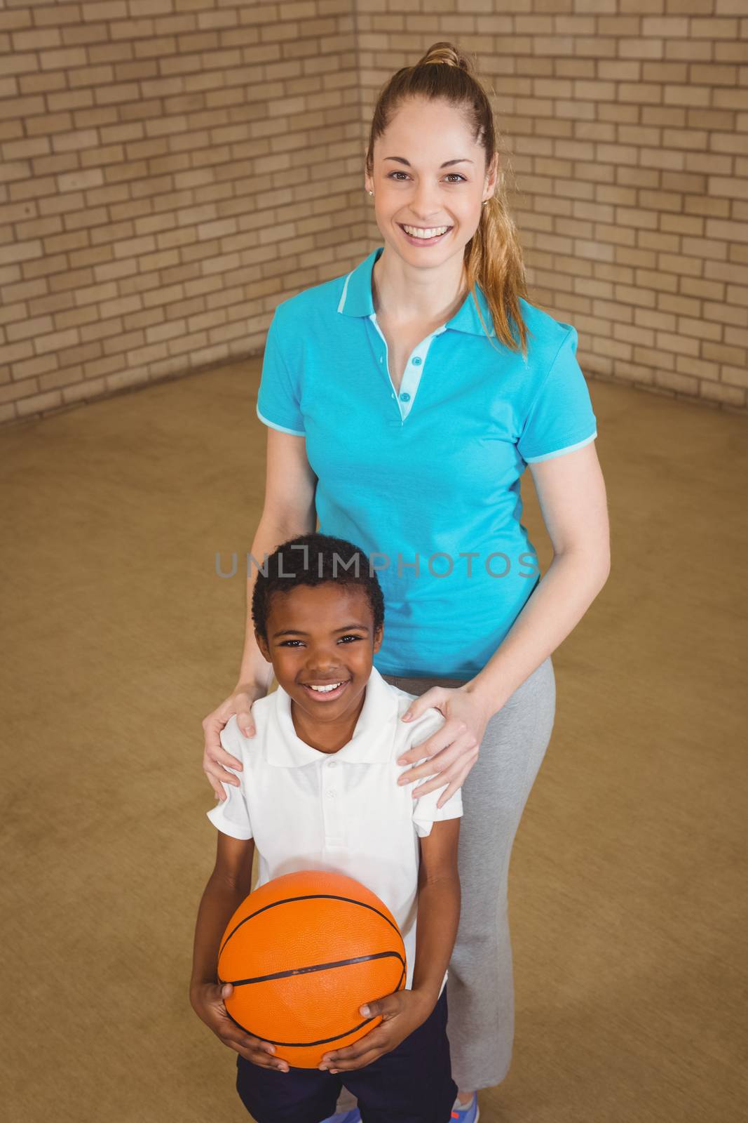 Student holding basketball with teacher at the elementary school