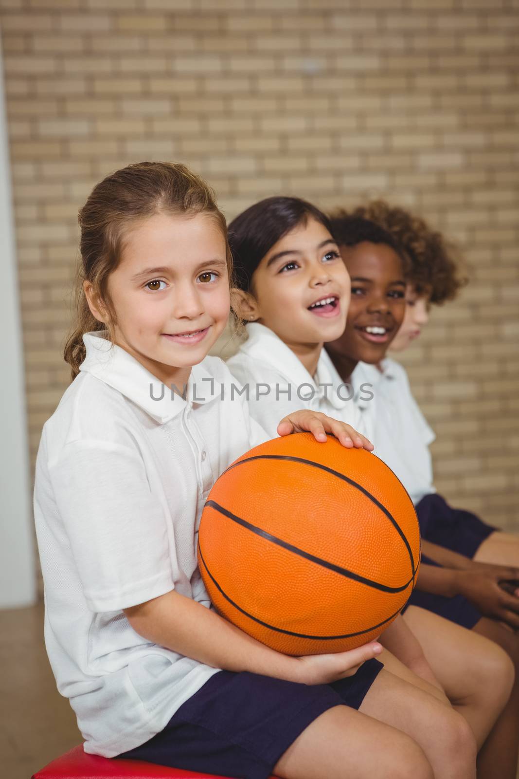 Student holding basketball with fellow players by Wavebreakmedia