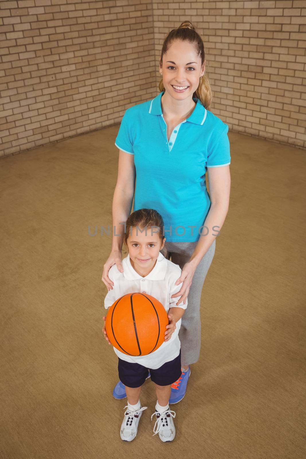 Student holding basketball with teacher at the elementary school