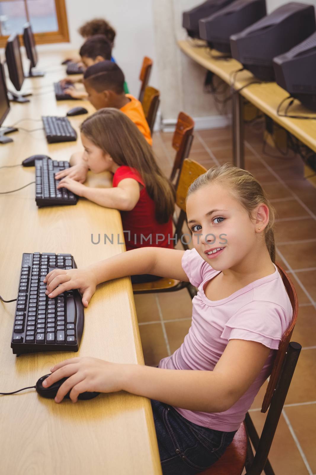 Smiling student using a computer at the elementary school
