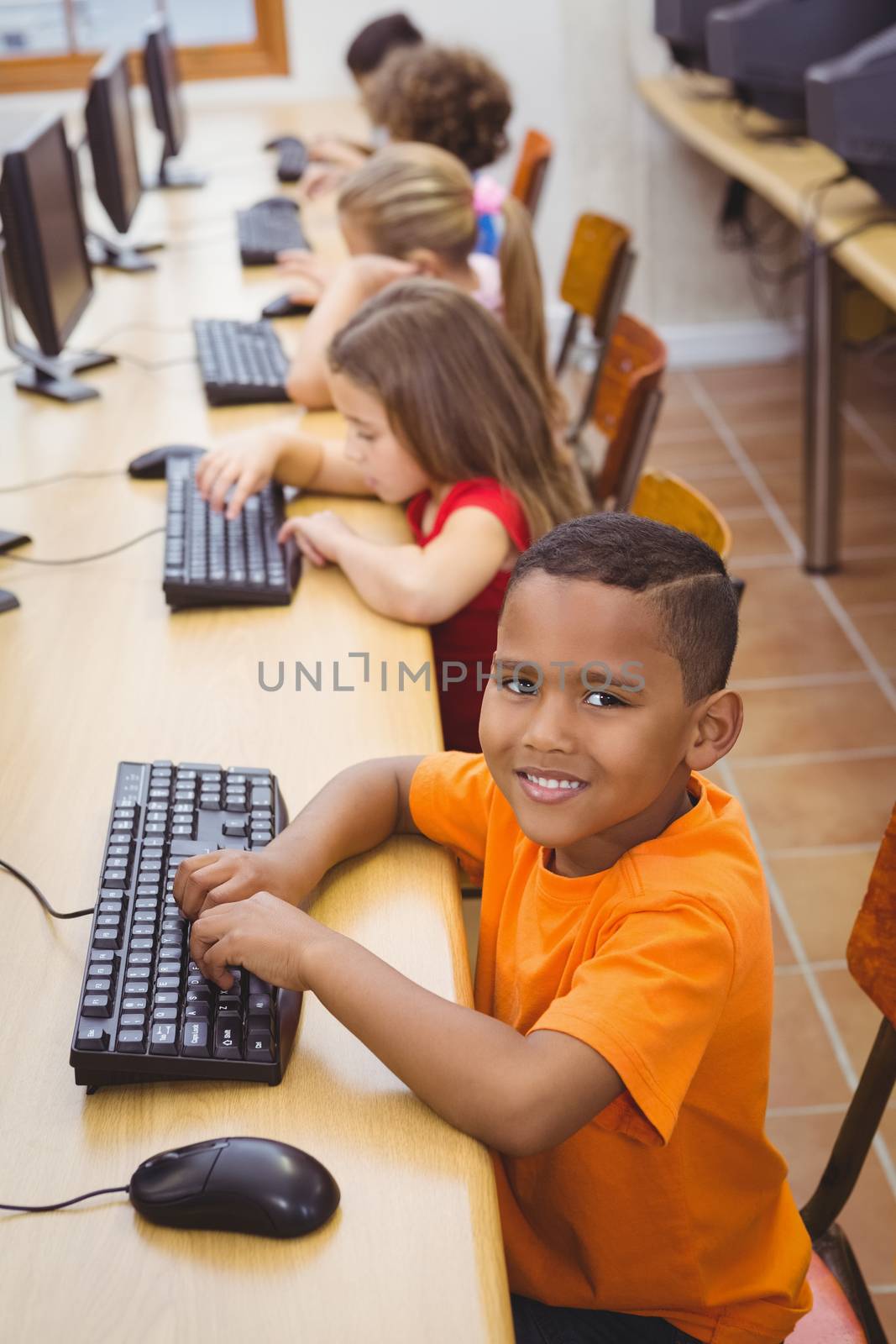 Smiling student using a computer by Wavebreakmedia