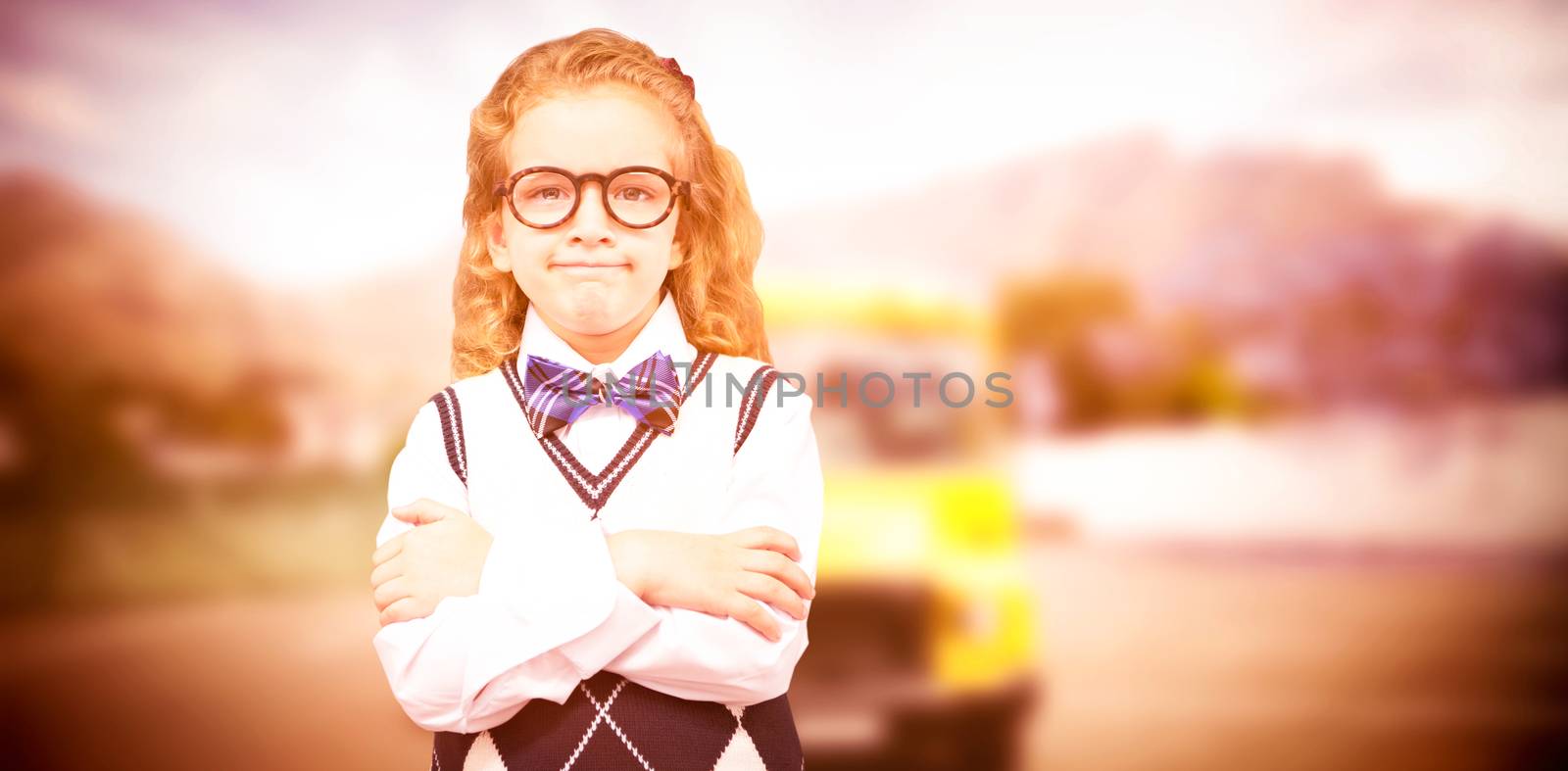 Cute pupil with arms crossed against yellow school bus waiting for pupils