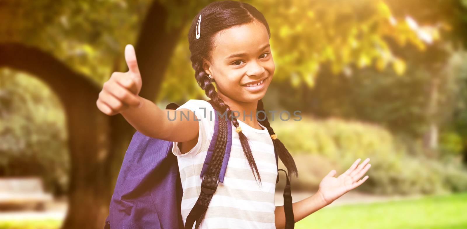 Pupil showing thumbs up against trees and meadow in the park