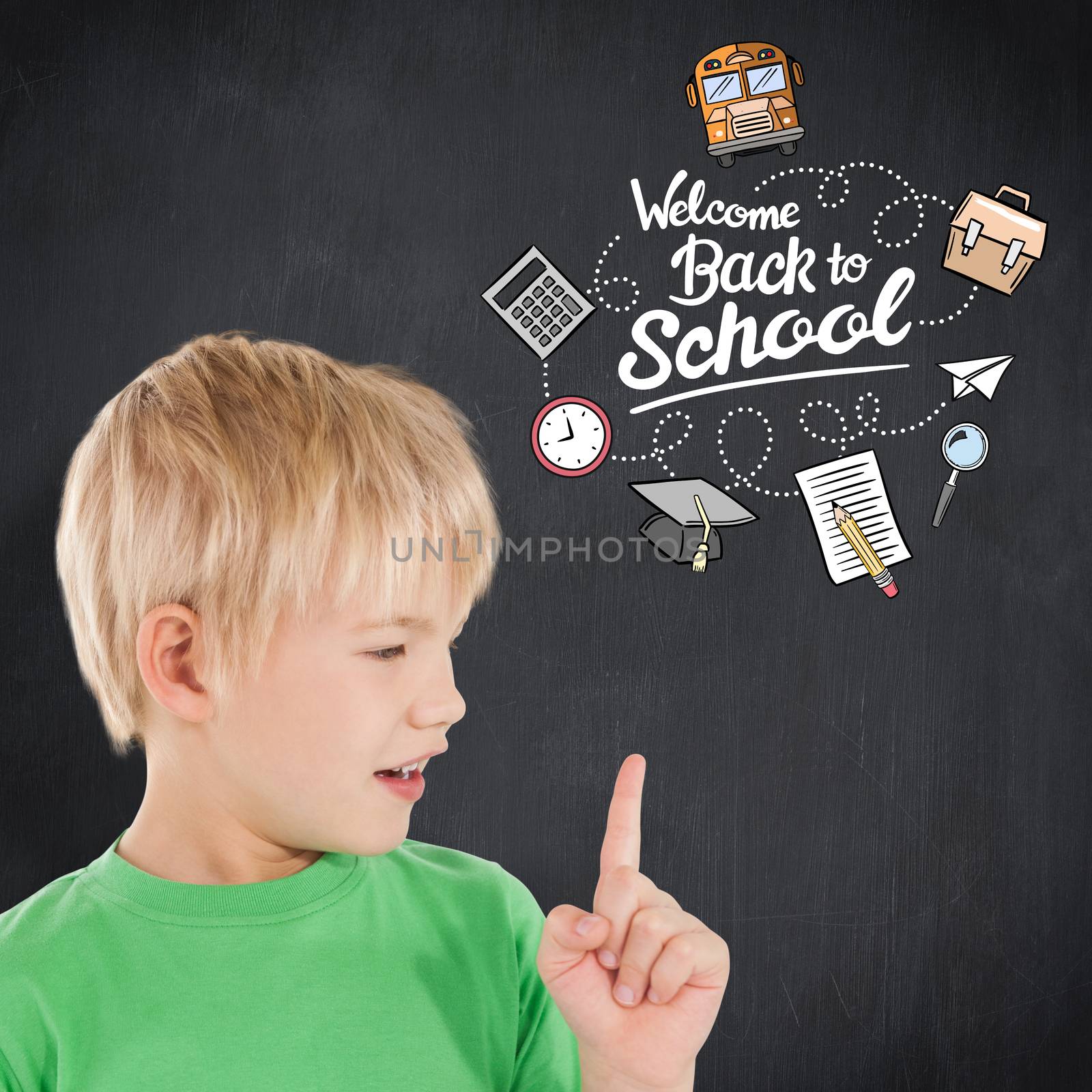 Cute boy pointing against blackboard