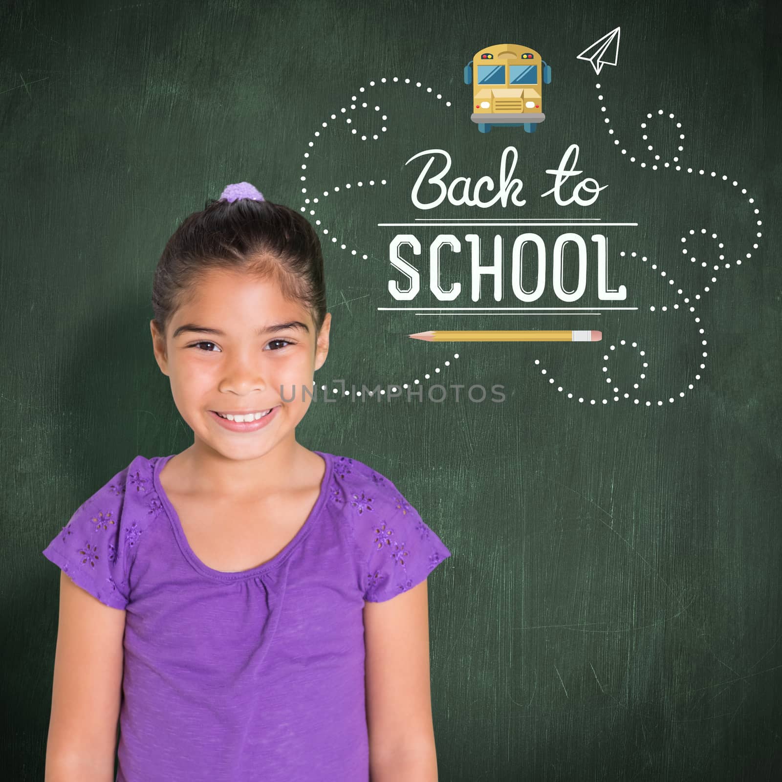 Cute girl smiling at camera against green chalkboard