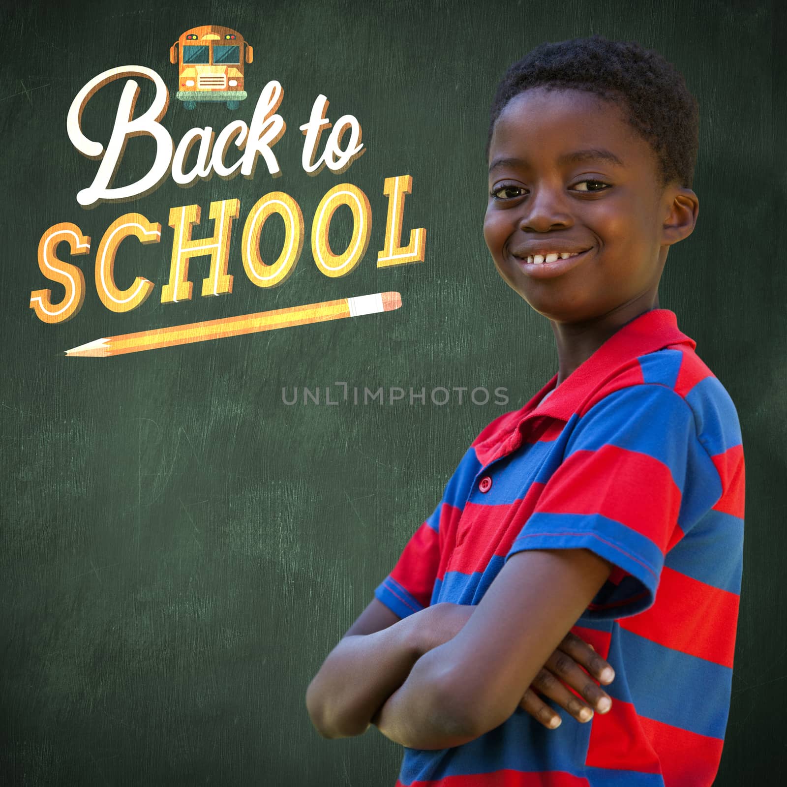 Cute little boy smiling at camera against green chalkboard