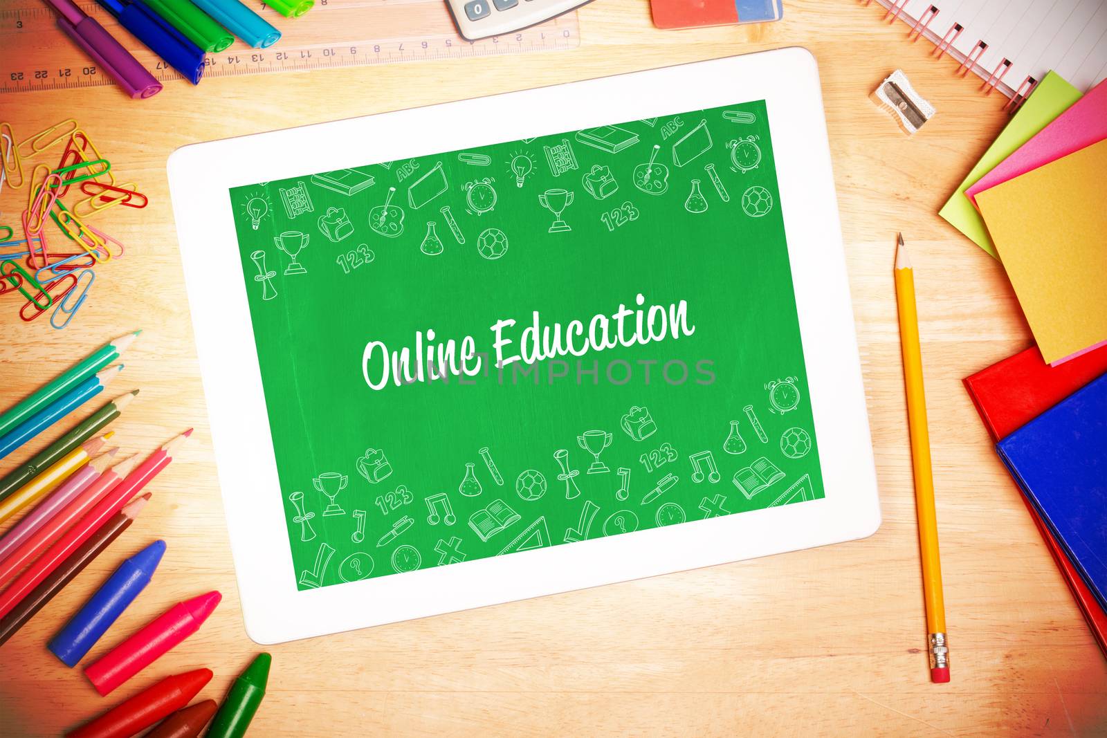 The word online education and school wallpaper against students desk with tablet pc