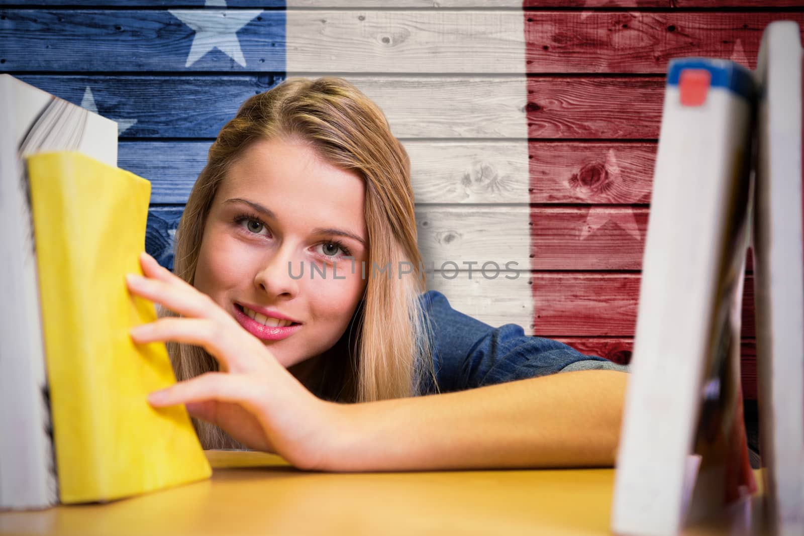 Pretty student in the library against composite image of usa national flag