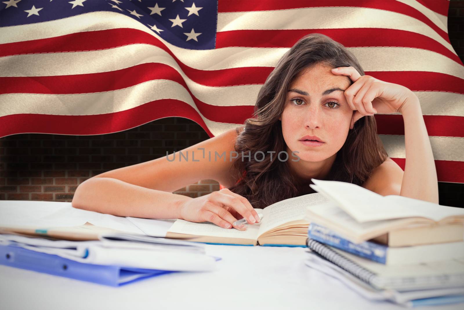 Bored student doing her homework against composite image of digitally generated united states national flag