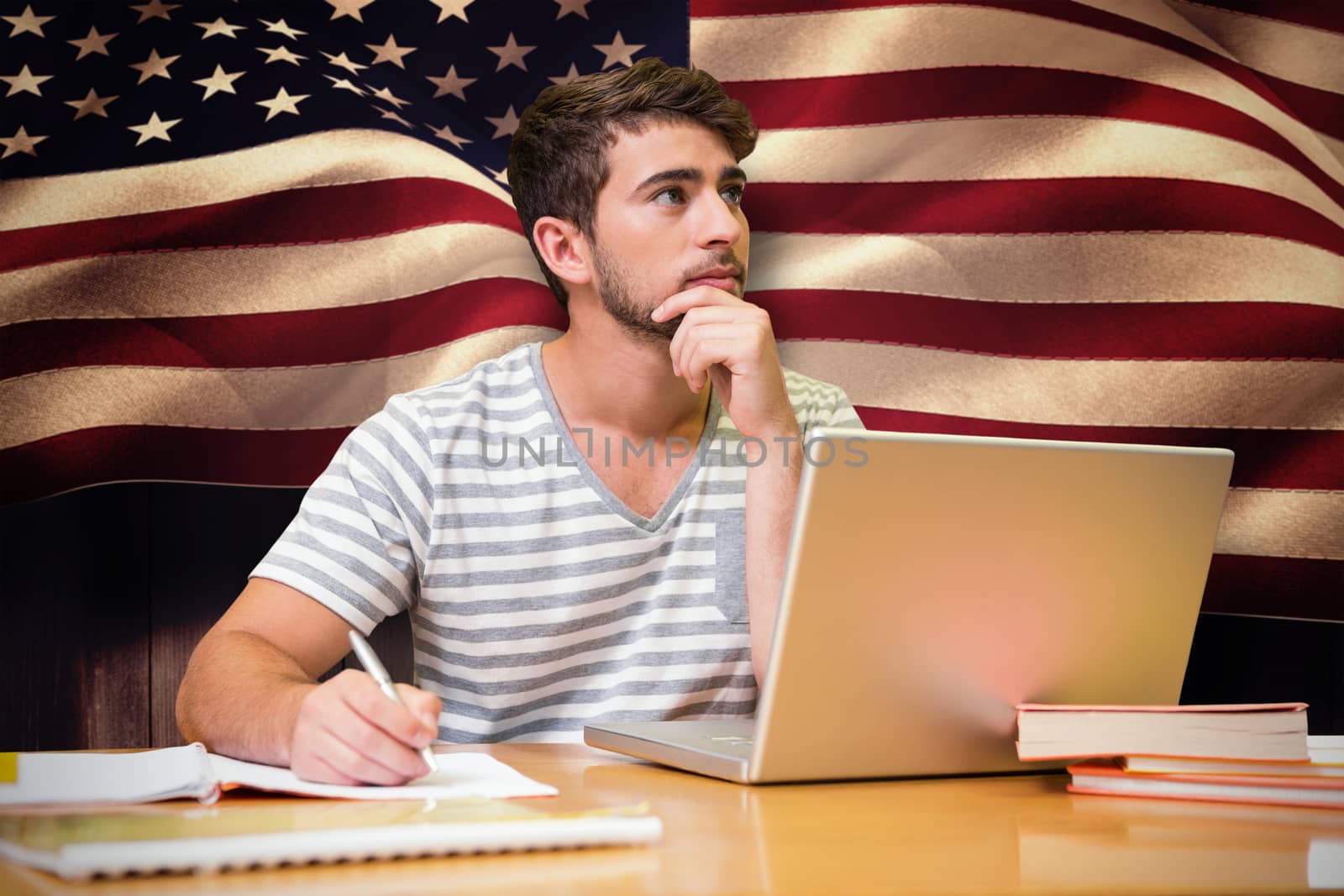 Student studying in the library with laptop against composite image of digitally generated united states national flag