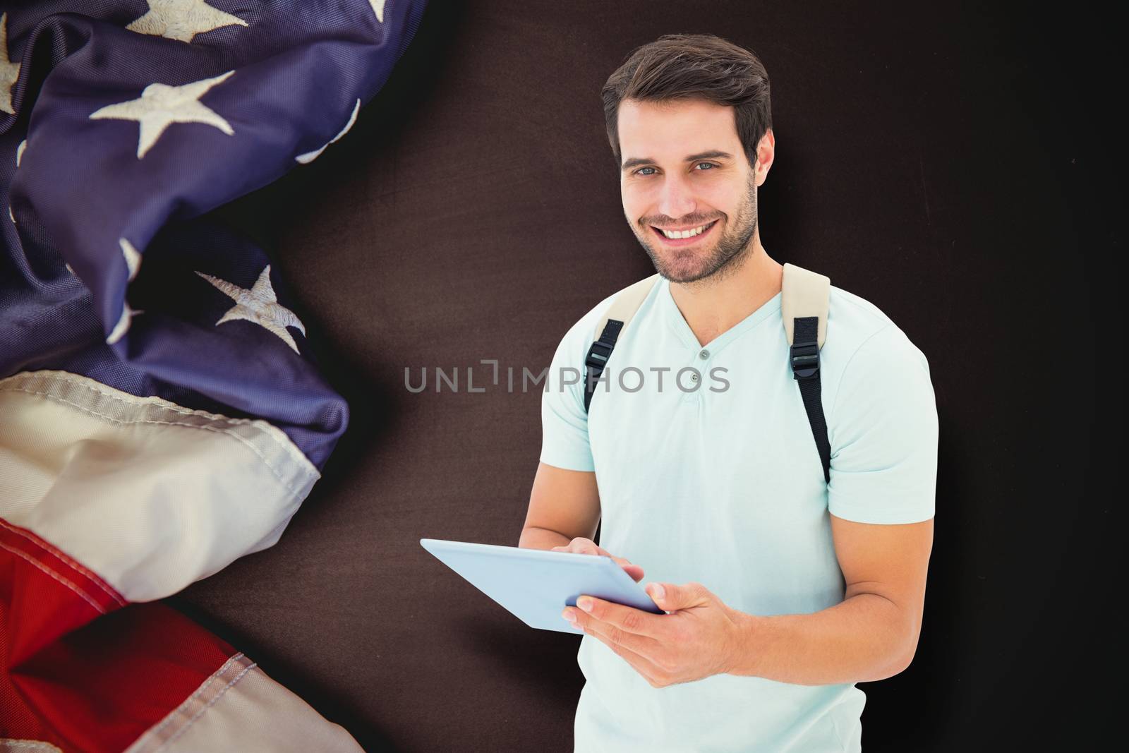 Student using tablet pc against american flag on chalkboard