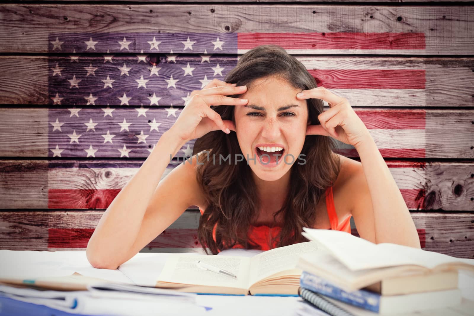 Student goes crazy doing her homework against composite image of usa national flag