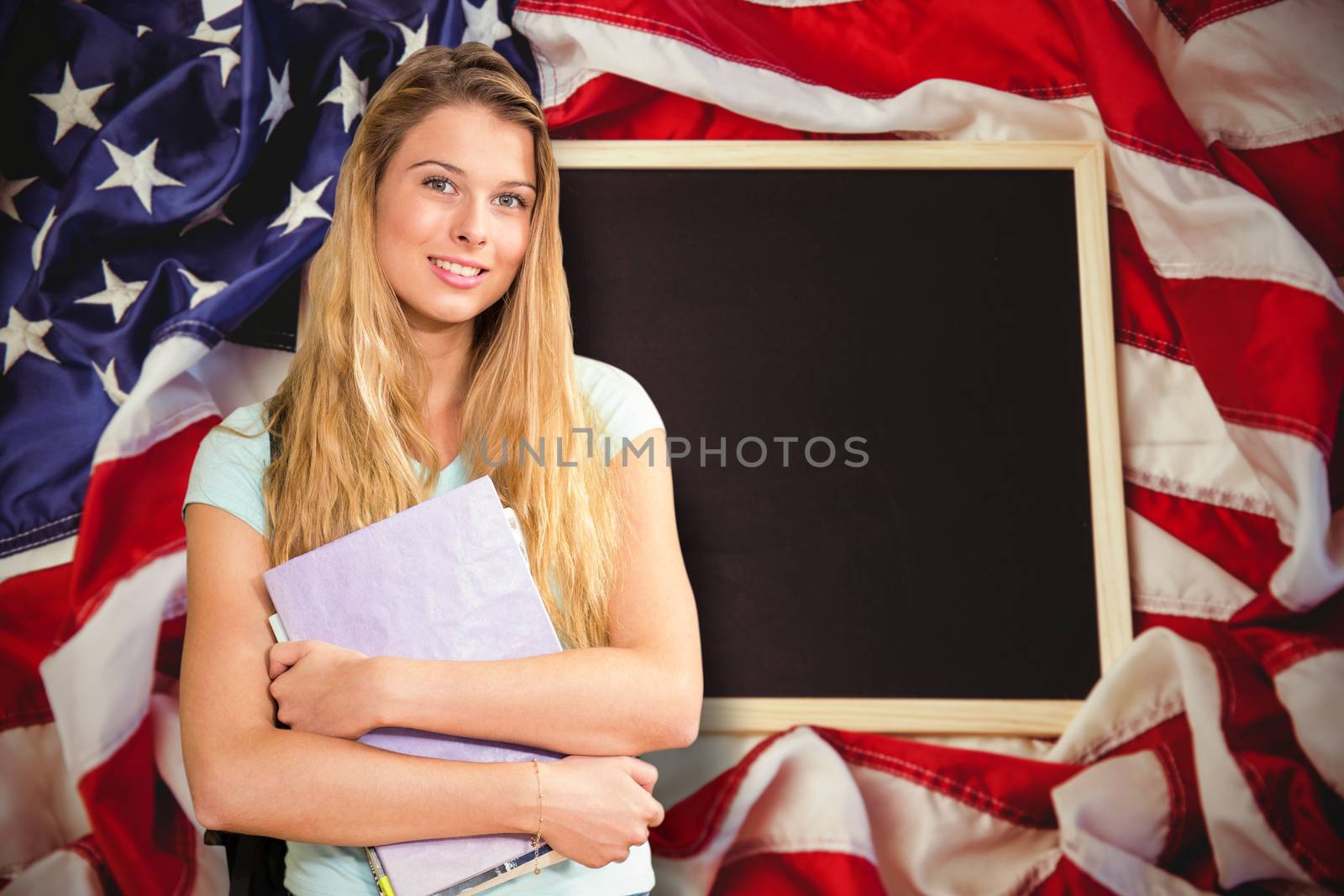 Happy student against american flag on chalkboard