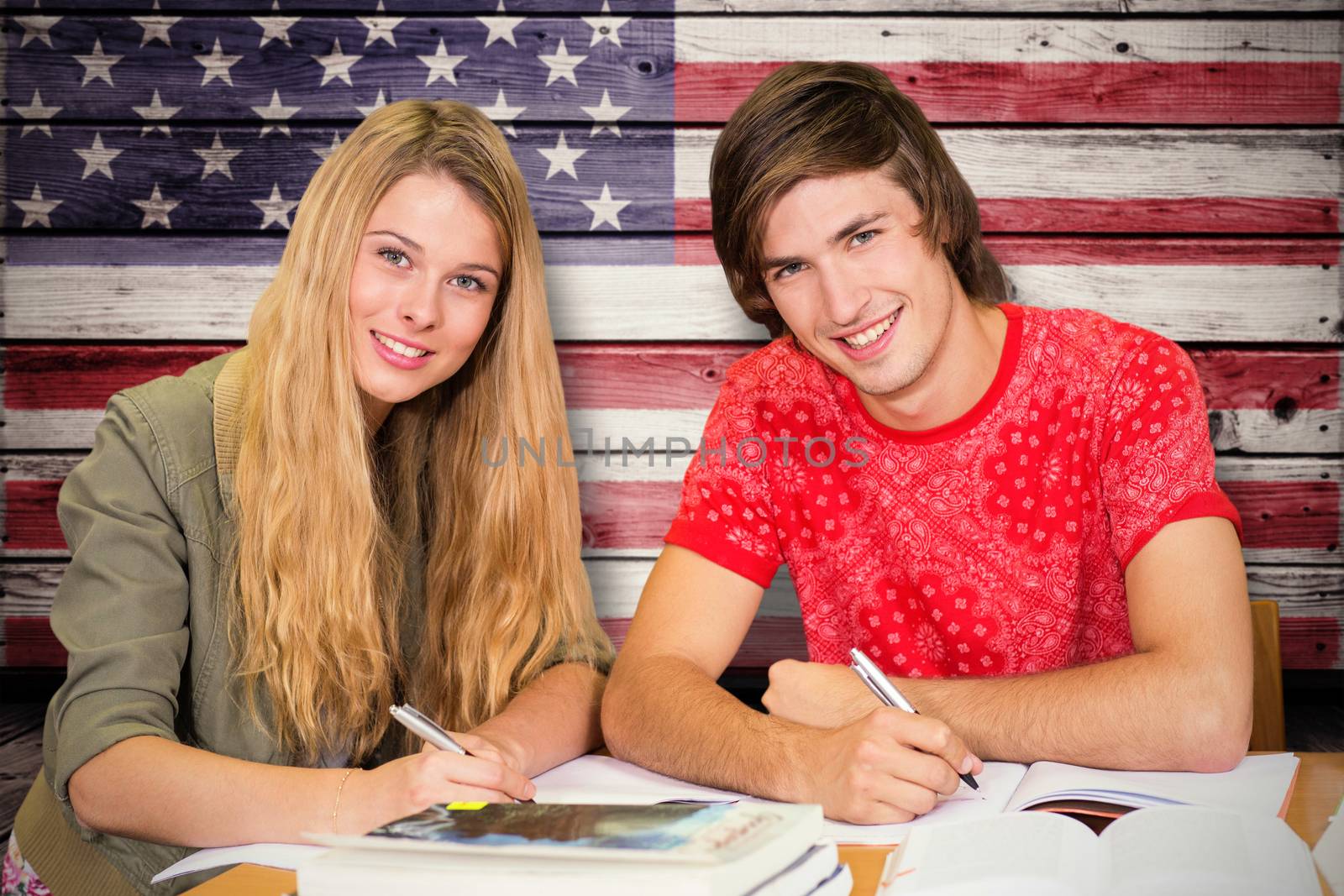 Students studying against composite image of usa national flag