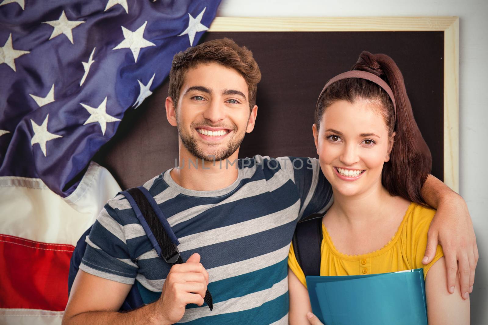 Happy students against american flag on chalkboard