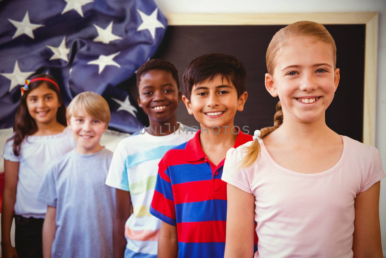 Smiling little school kids in school corridor against american flag on chalkboard