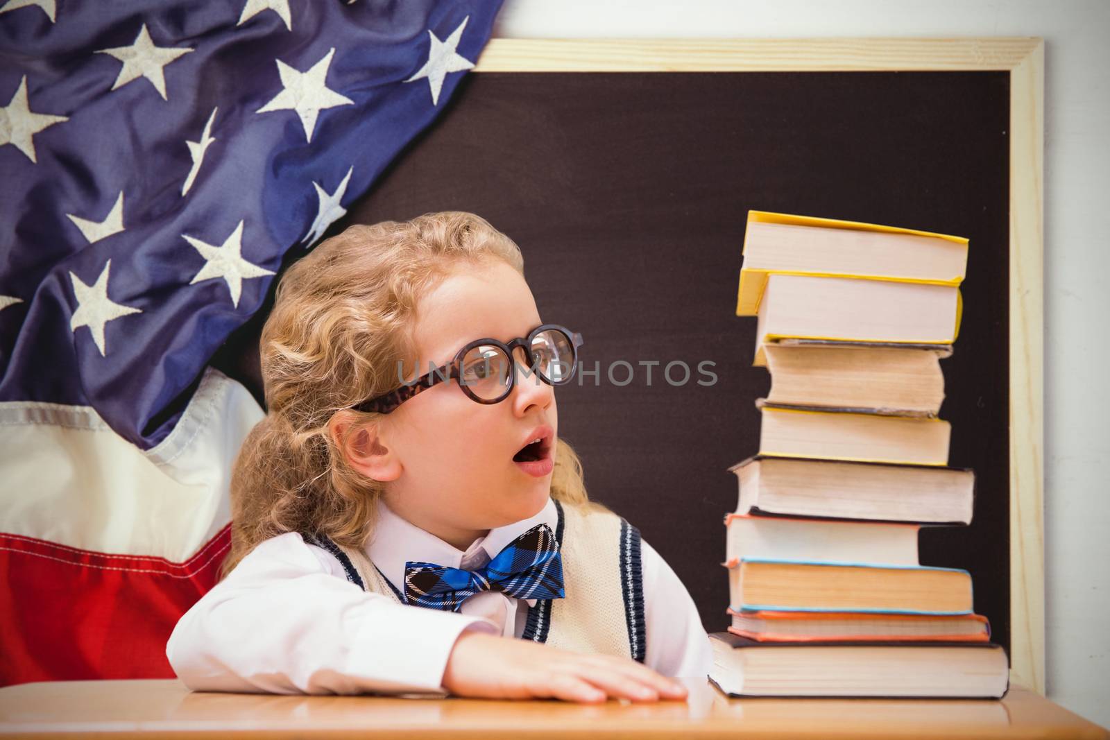 Surprise pupil looking at books against american flag on chalkboard