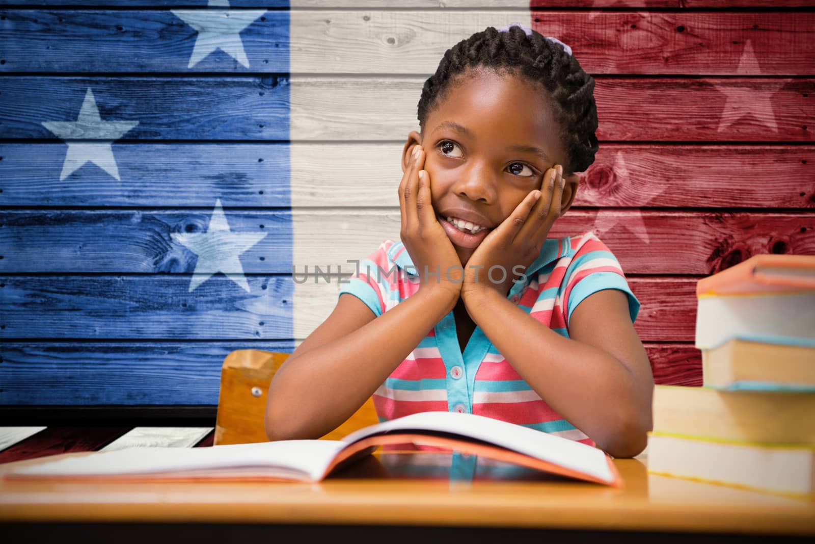 Pupil sitting at her desk  against composite image of usa national flag