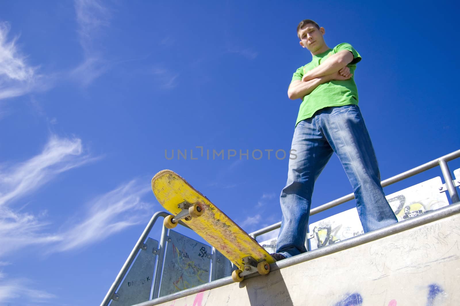 Sport conceptual image.  Teenage skateboarder standing on the ramp with skateboard.