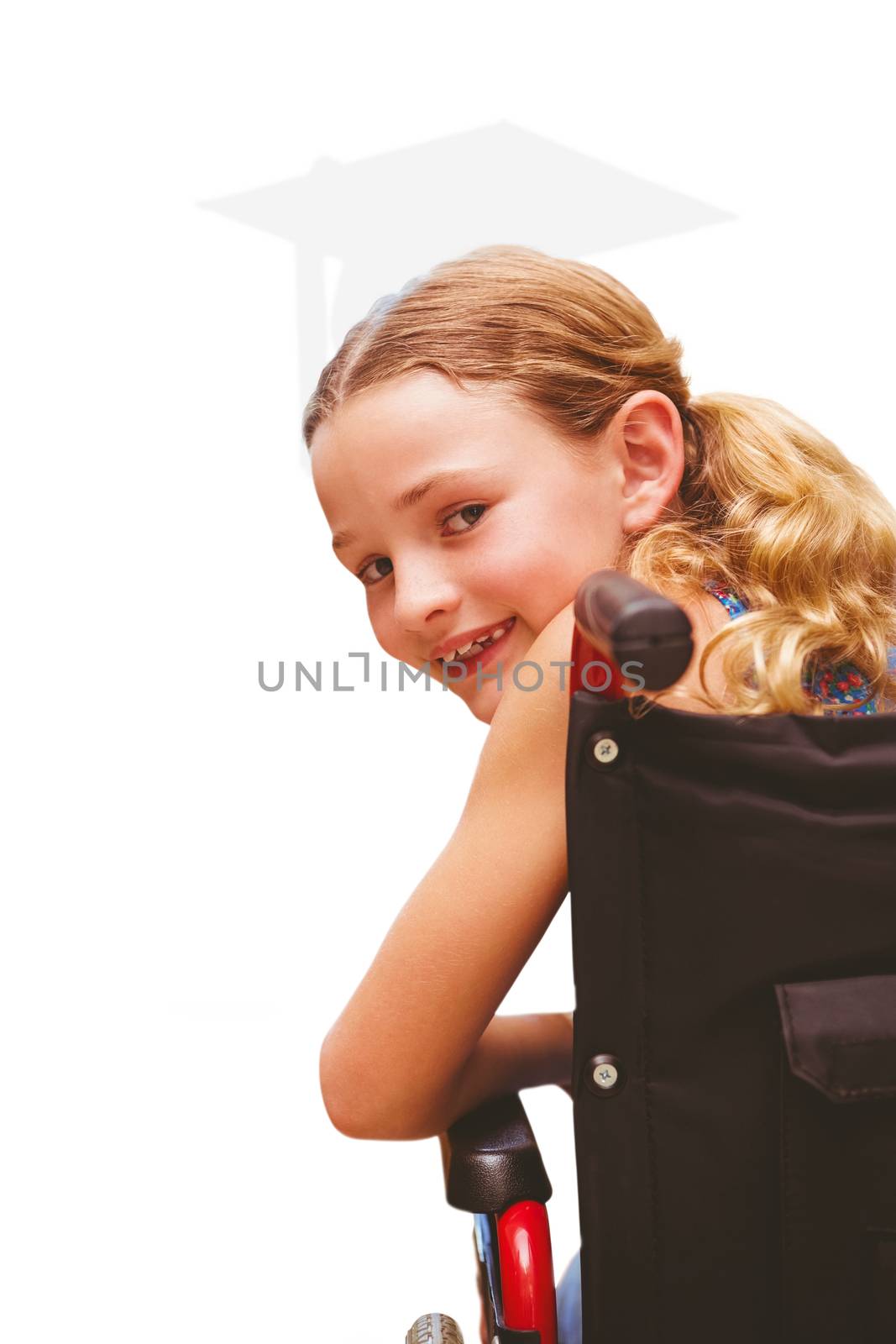 Portrait of cute girl sitting in wheelchair against silhouette of graduate