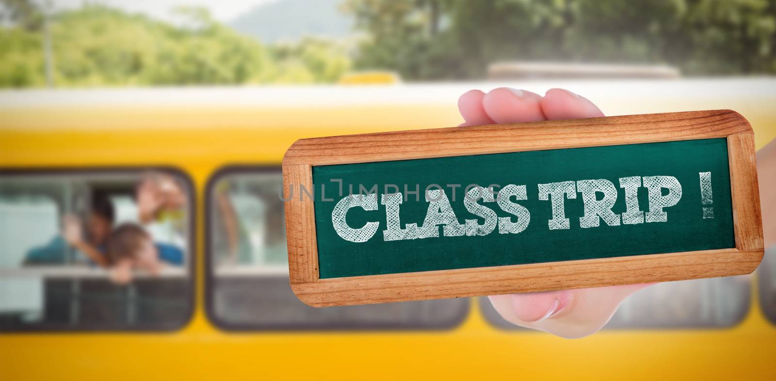 The word class trip! and hand showing chalkboard against cute pupils smiling at camera in the school bus