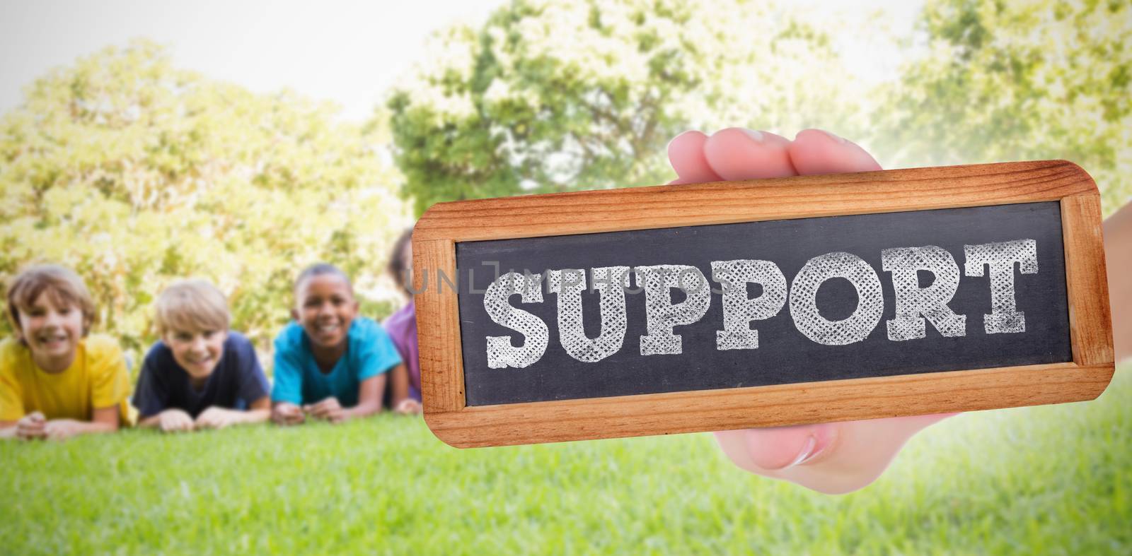 The word support and hand showing chalkboard against happy friends in the park 