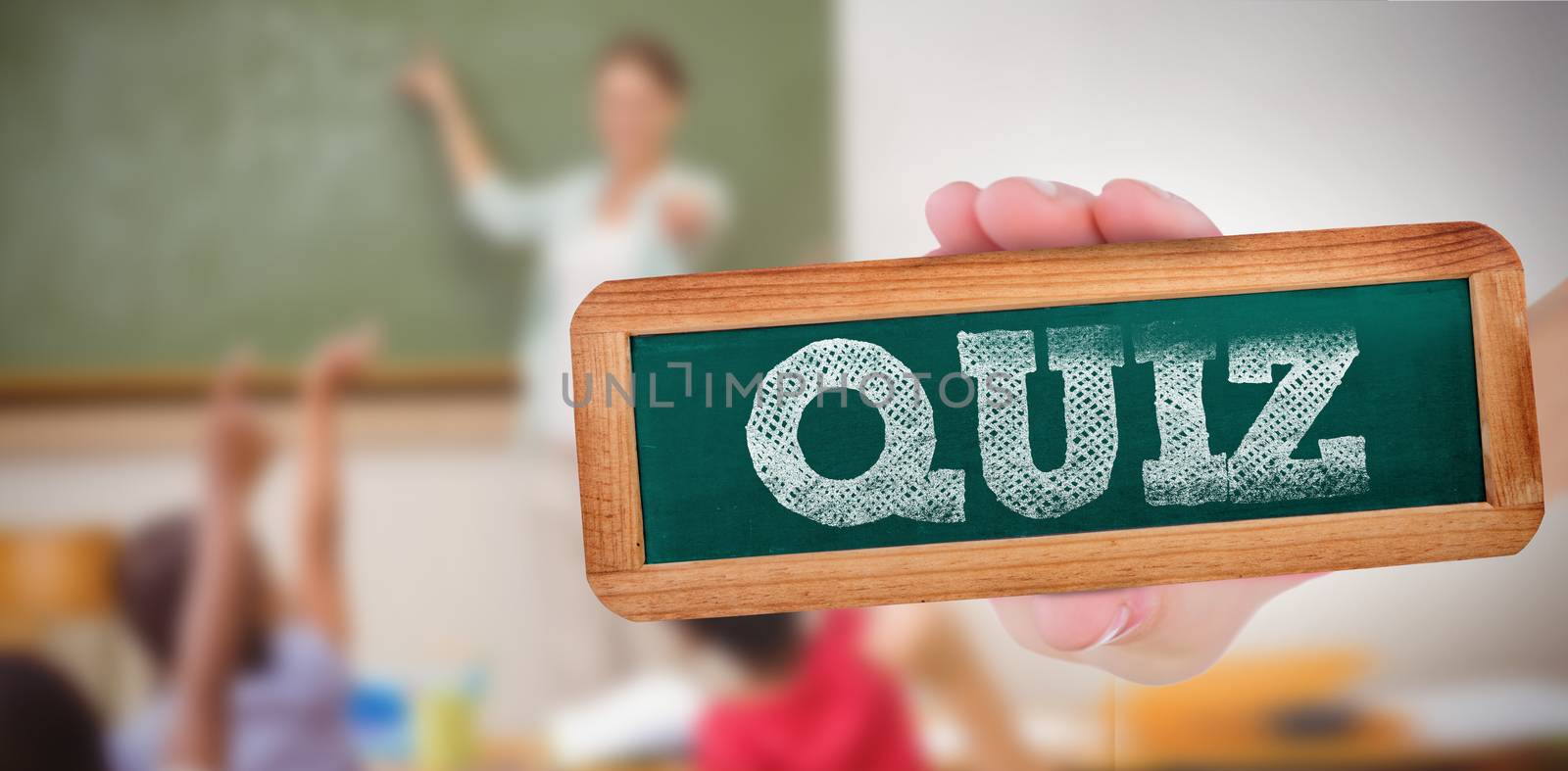 The word quiz and hand showing chalkboard against pupils raising their hands during class