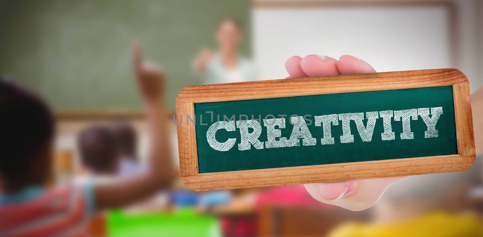 The word creativity and hand showing chalkboard against pupils raising their hands during class