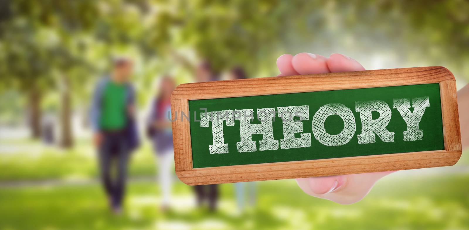 The word theory and hand showing chalkboard against froup of college students walking in the park
