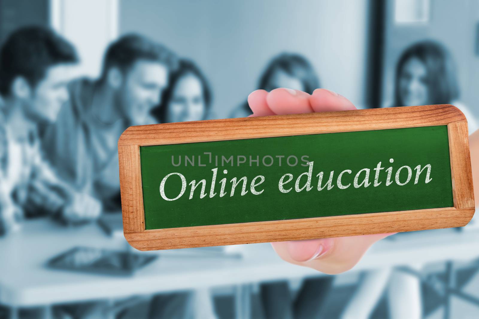 The word online education and hand showing chalkboard against smiling friends students using laptop