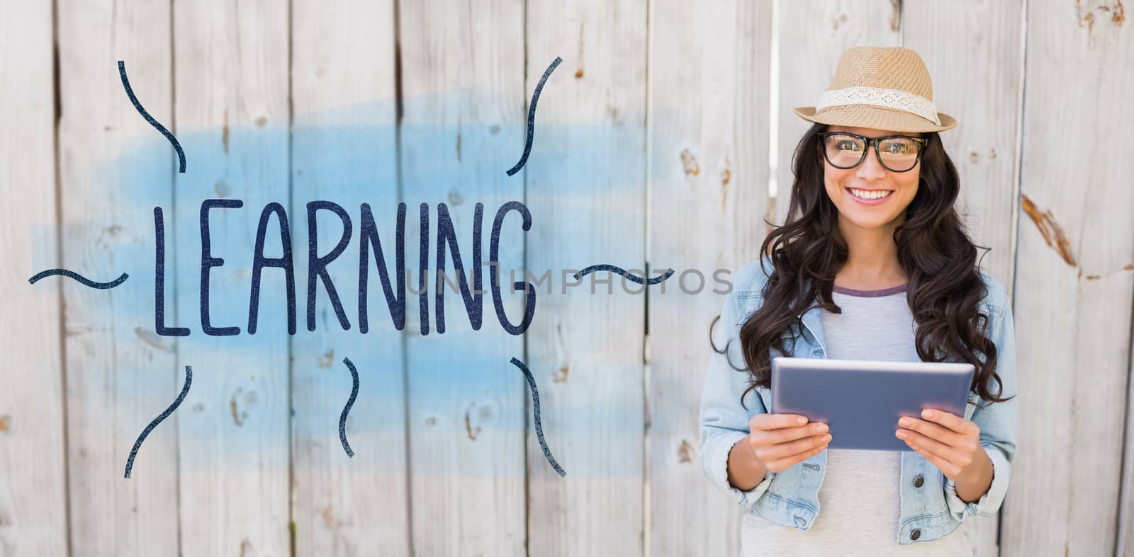 The word learning against pretty hipster smiling at camera holding tablet