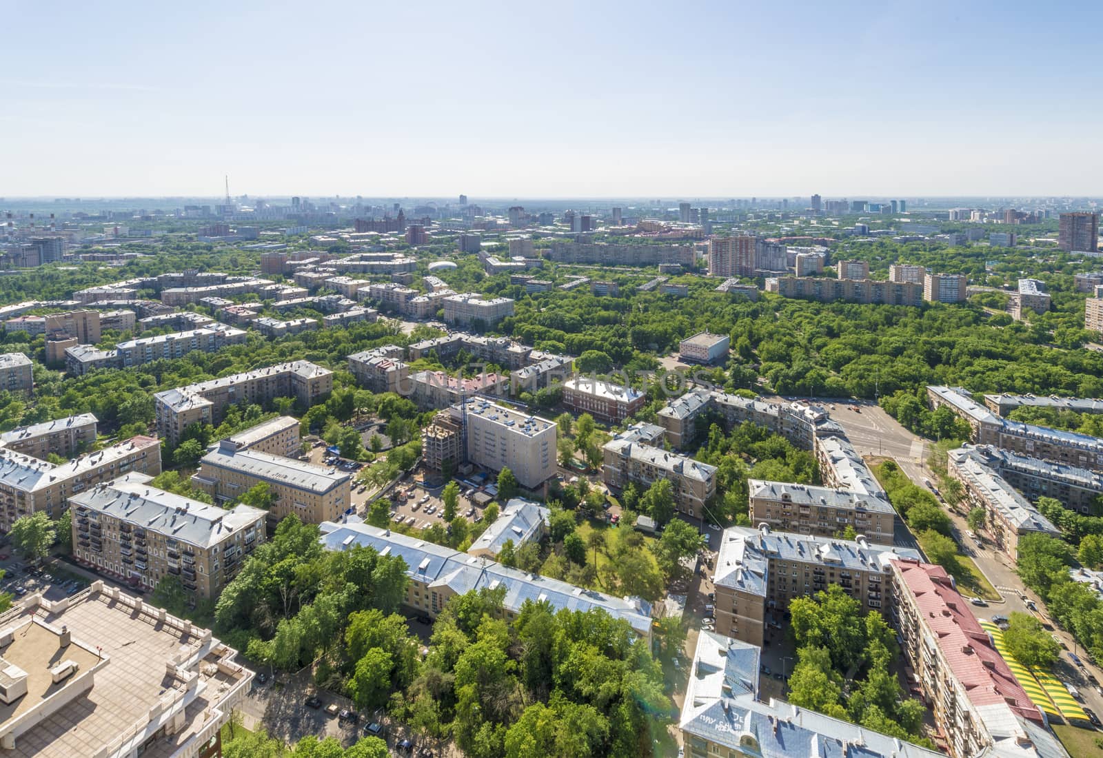 View of Moscow modern residential quarters at sunset on top of the roof of a tall building by rogkoff