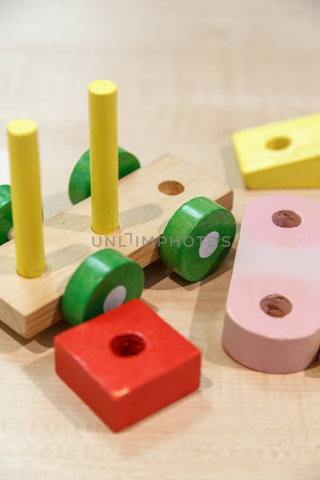 Close up view of multicolored wooden train toy puzzle, on wooden table background.