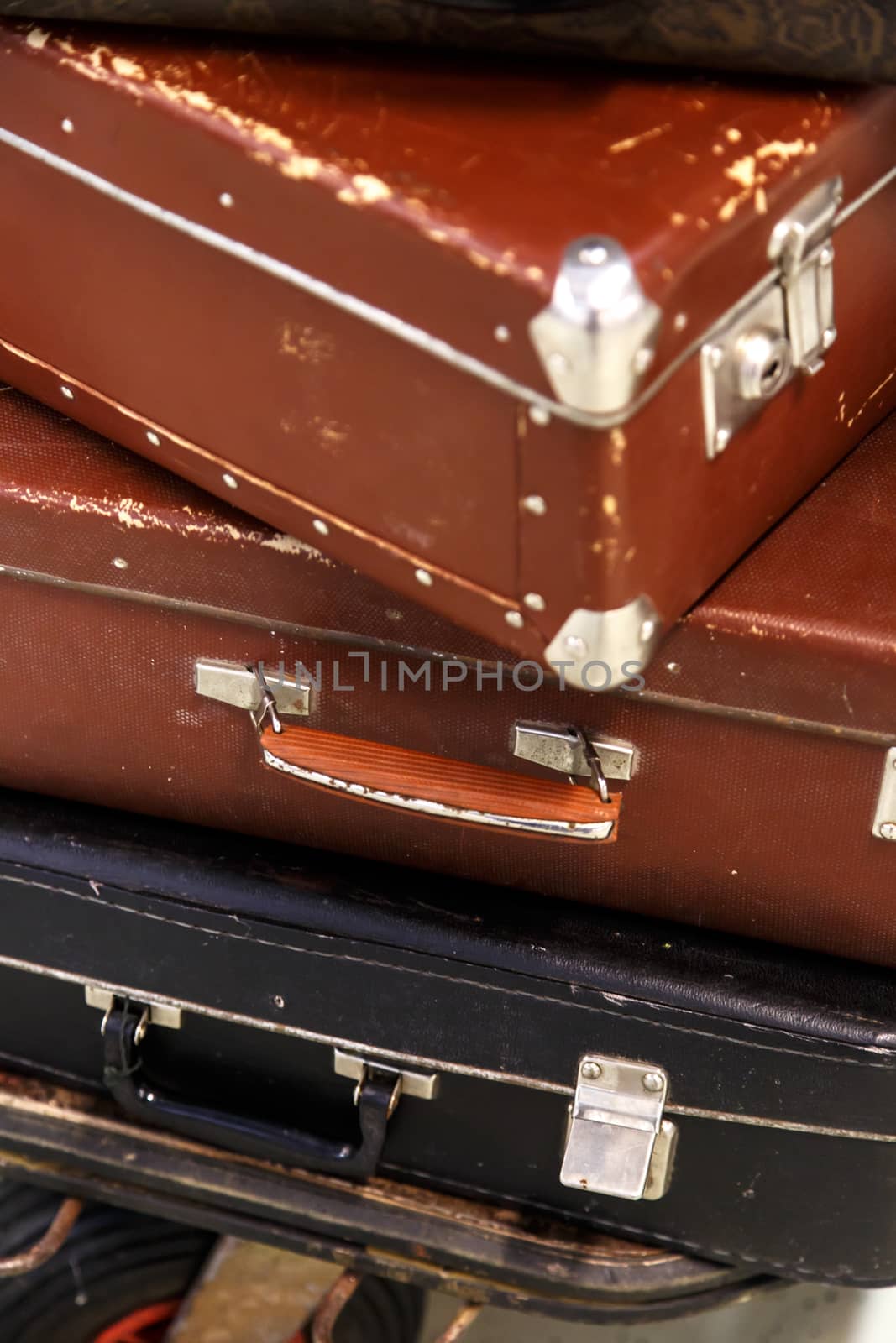 Close up detailed view of old nostalgical brown leather and fabric suitcases on end.