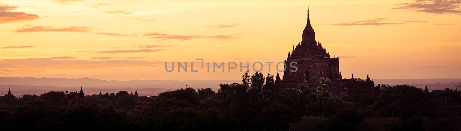 Panoramic landscape view of ancient temples silhouette at colorful golden sunset, Bagan, Myanmar
