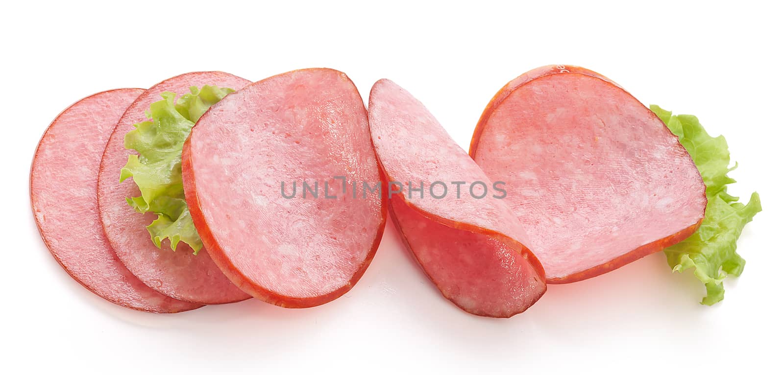 Some pieces pf smoked sausage with fresh green lettuce on the white