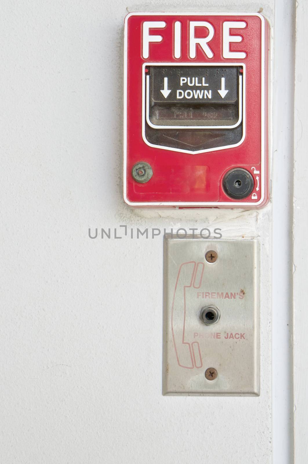 Old red box of fire alarm on white wall background by eaglesky