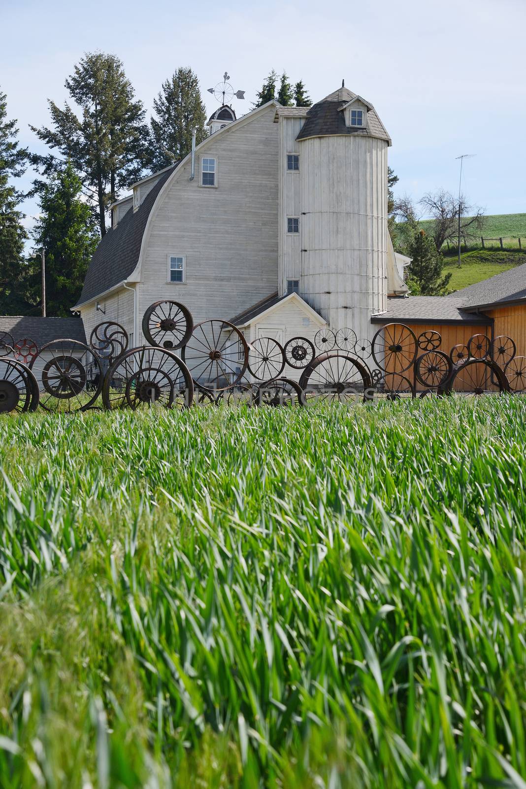 a barn with wheel fence by porbital
