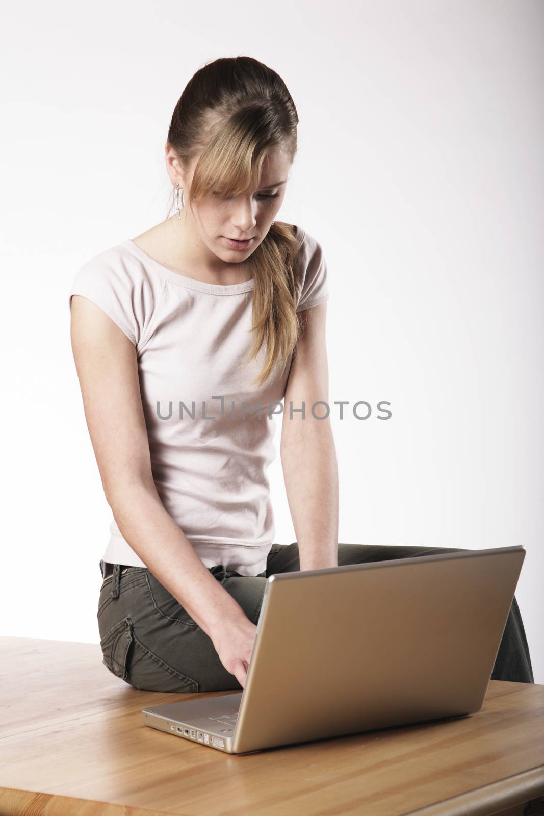 Young woman sitting at a table in front of her computer