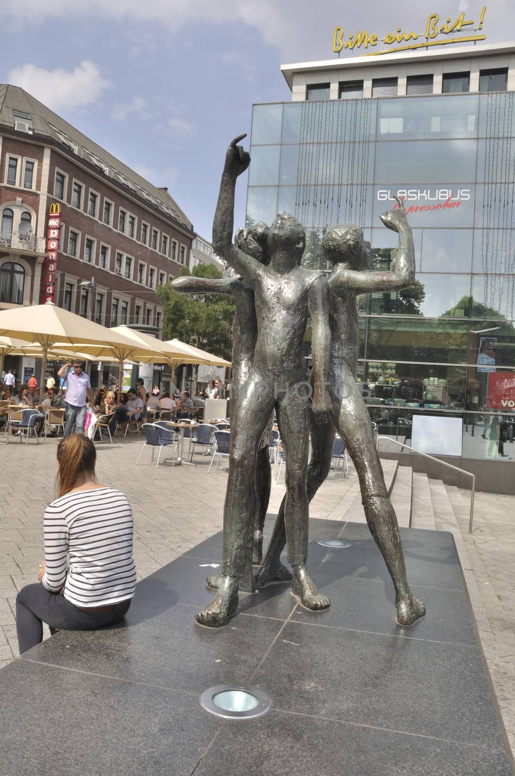 AACHEN,GERMANY- JULY 26, 2014: Woman and the Klenkes monument and Glass Housewith pavement cafes in Aachen