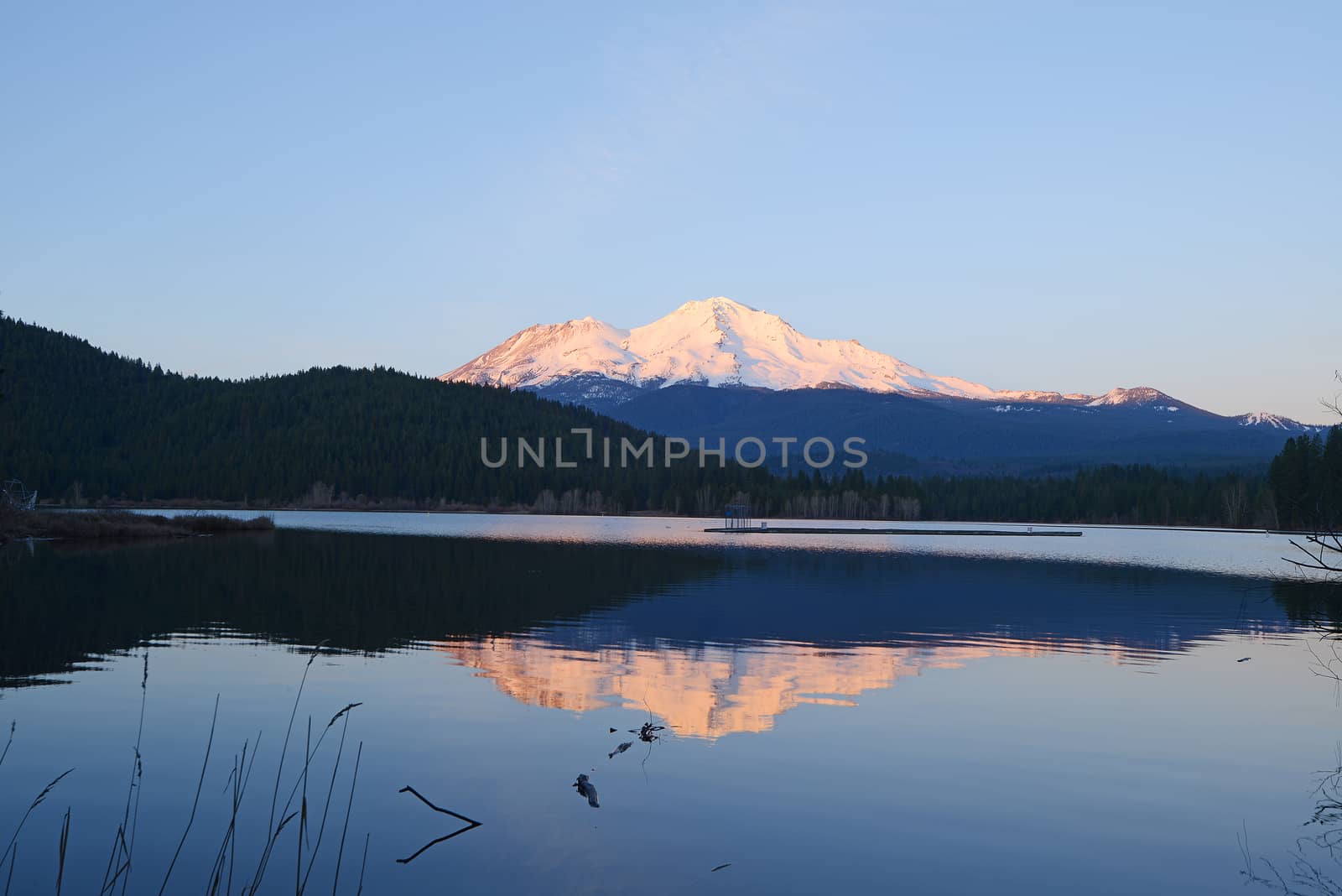 a reflection of mount shasta over a lake during sunset