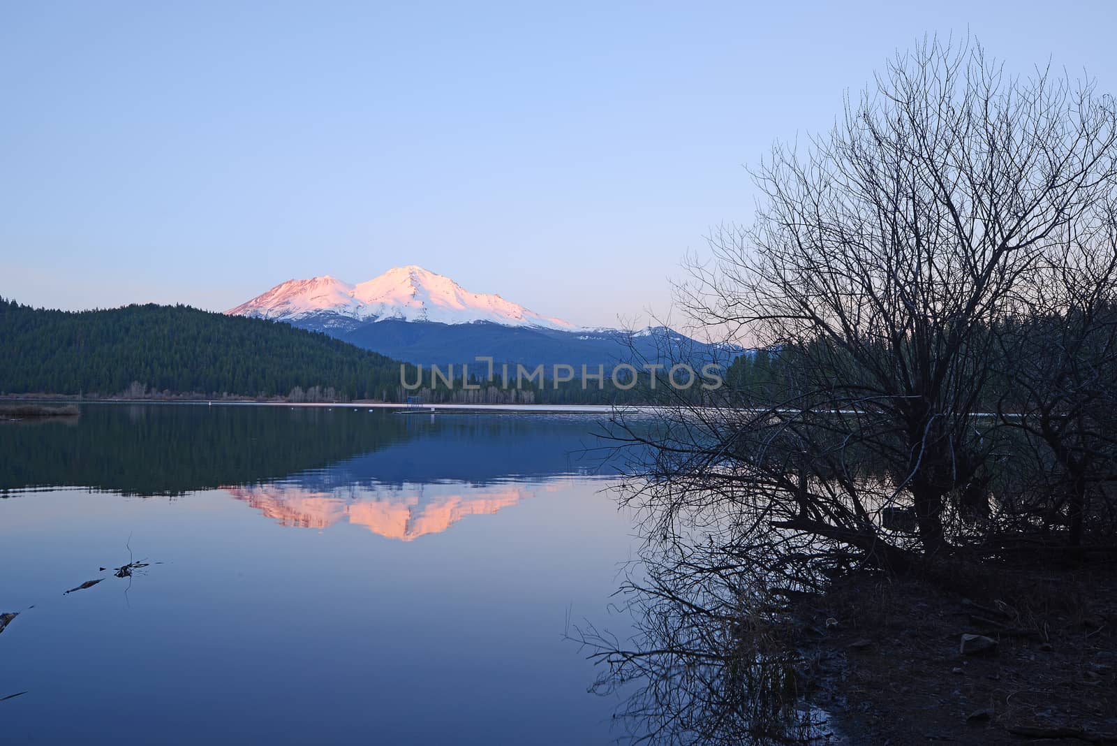 a reflection of mount shasta over a lake during sunset