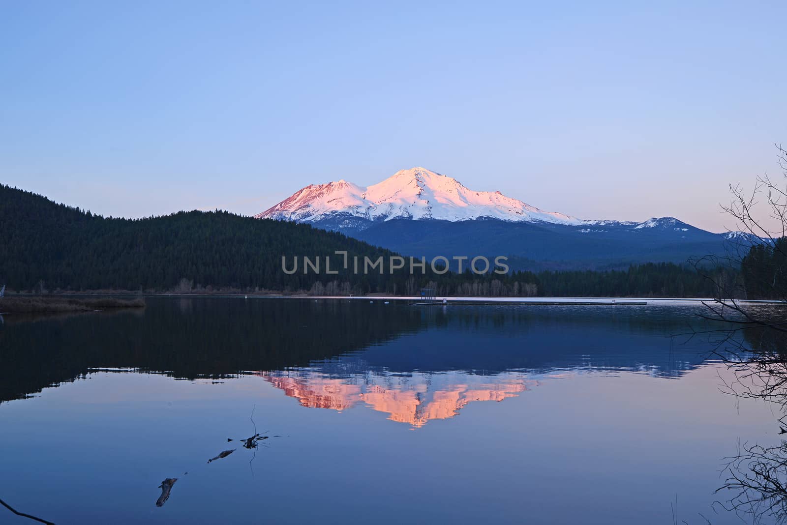 a reflection of mount shasta over a lake during sunset