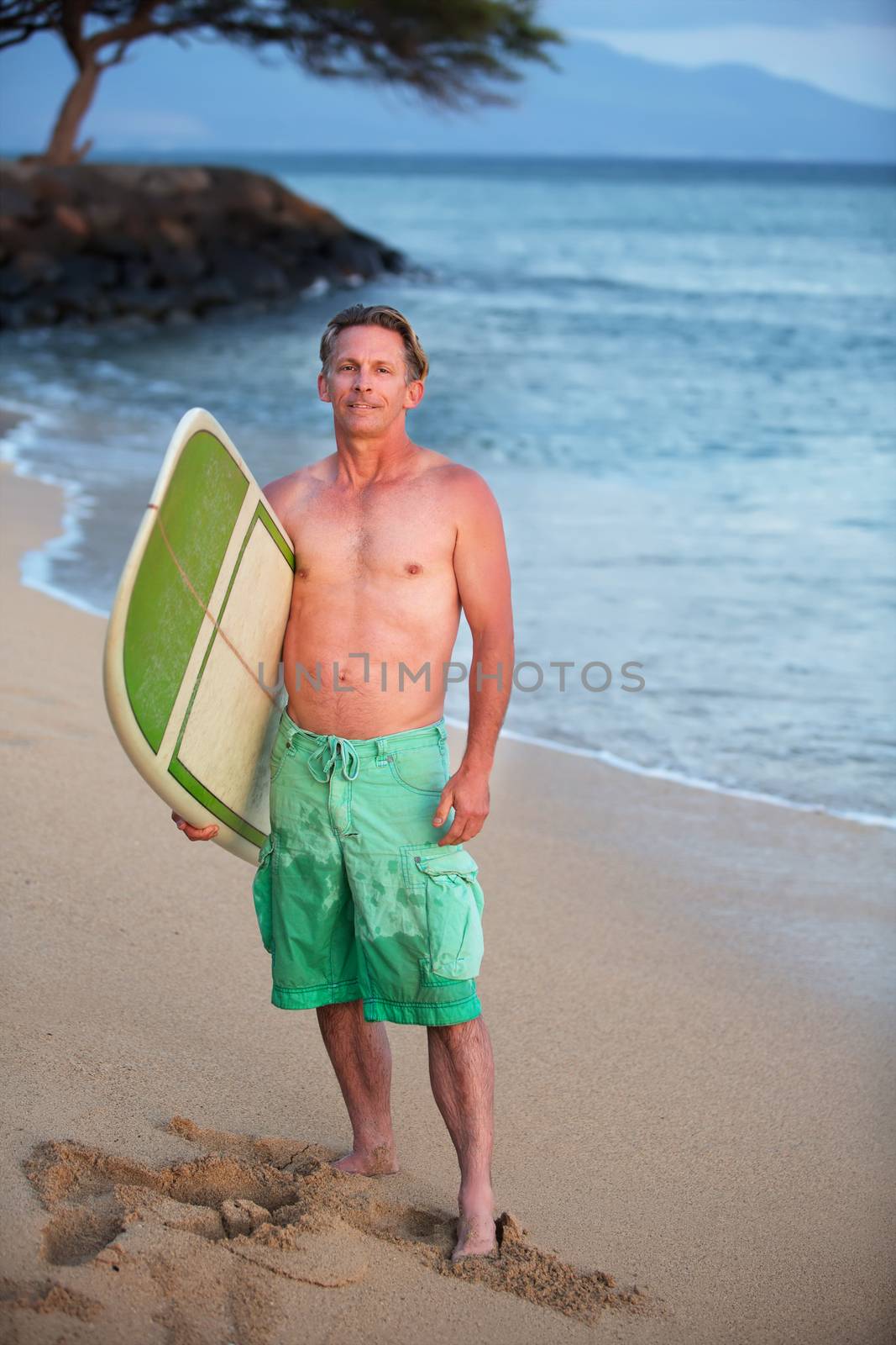 Single adult Caucasian male outdoors with surfboard at shoreline